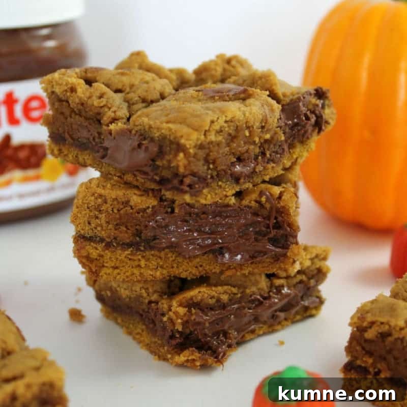 Top Fall Dessert Recipes You Need to Try This Season 6 Pumpkin Nutella Bars stacked next to a jar of Nutella in the background and a pumpkin