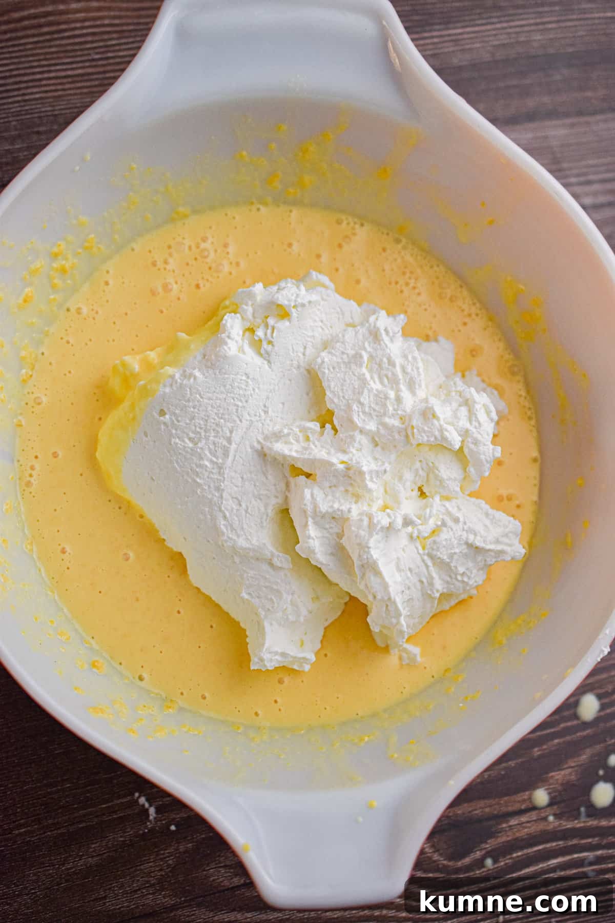 The whipped cream is added to the eggnog mixture.
