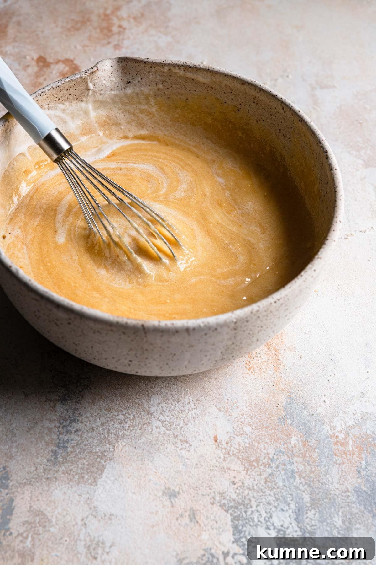 Light and Tender Passover Cake Recipe for a Perfect Seder 9 A whisk mixing meringue into a bake batter.