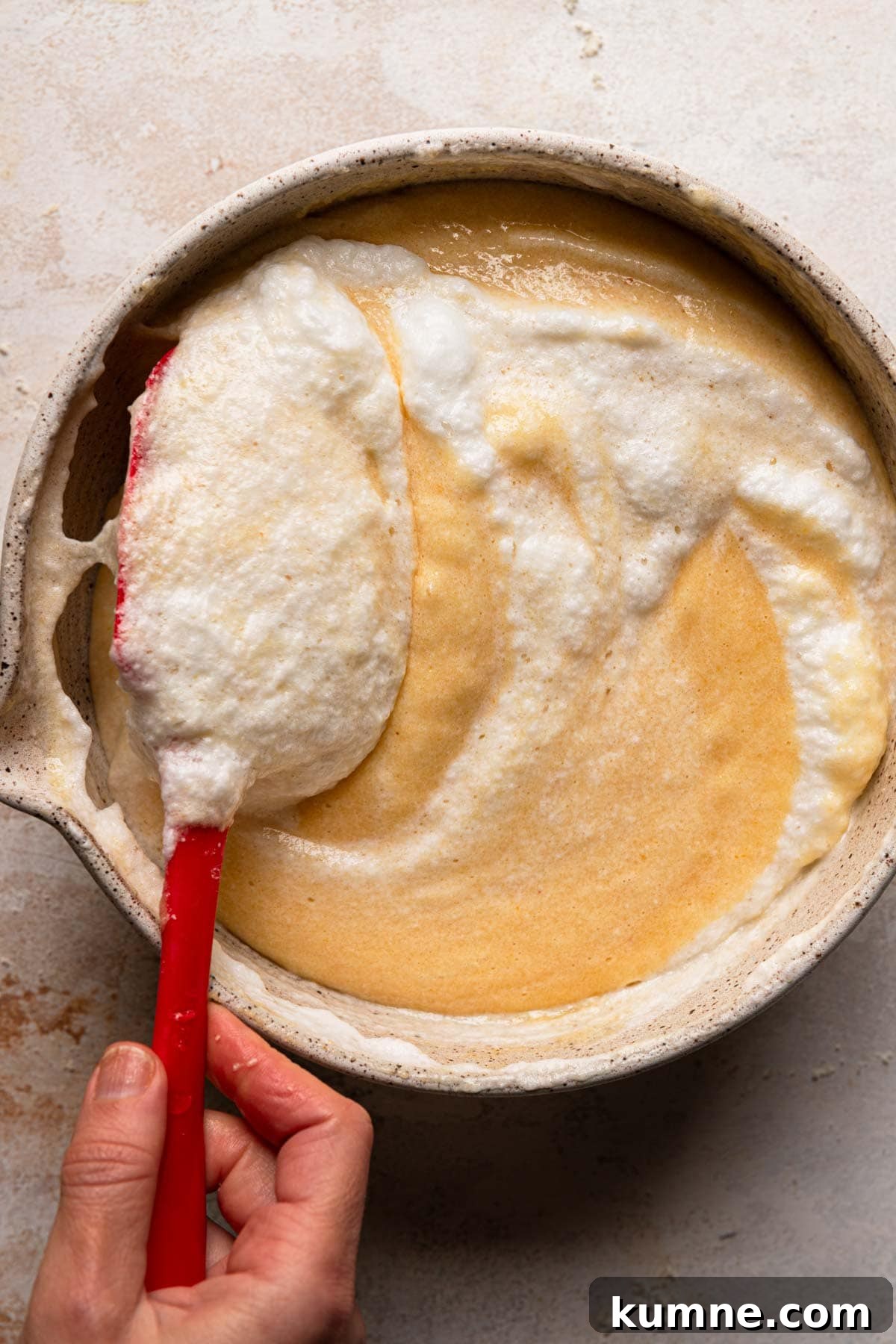 Light and Tender Passover Cake Recipe for a Perfect Seder 10 A hand folding meringue into cake batter.