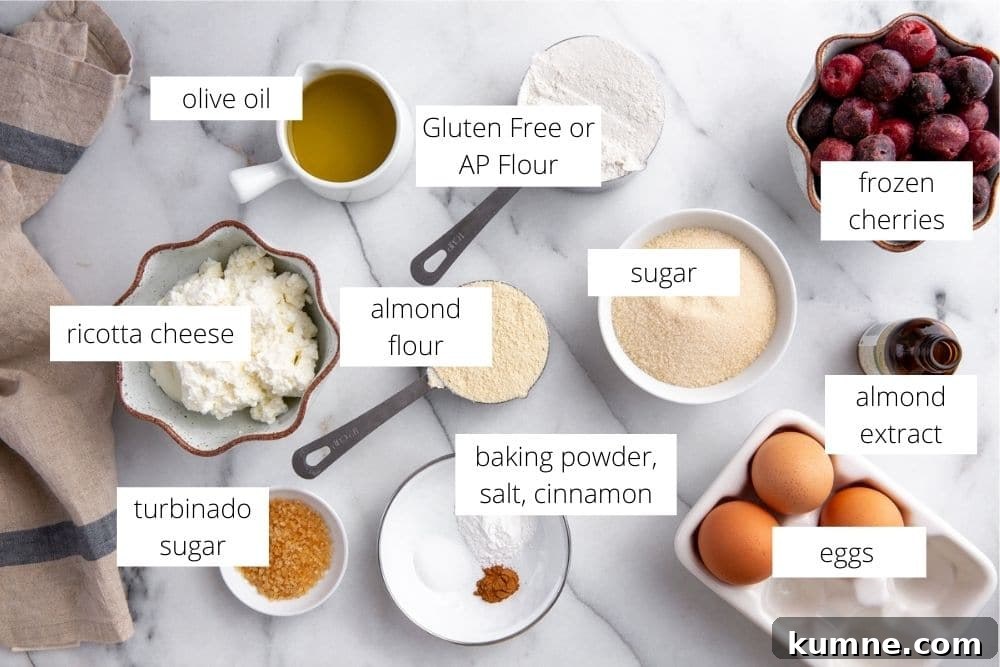All of the ingredients for the ricotta cake recipe arranged on a marble surface and labeled.