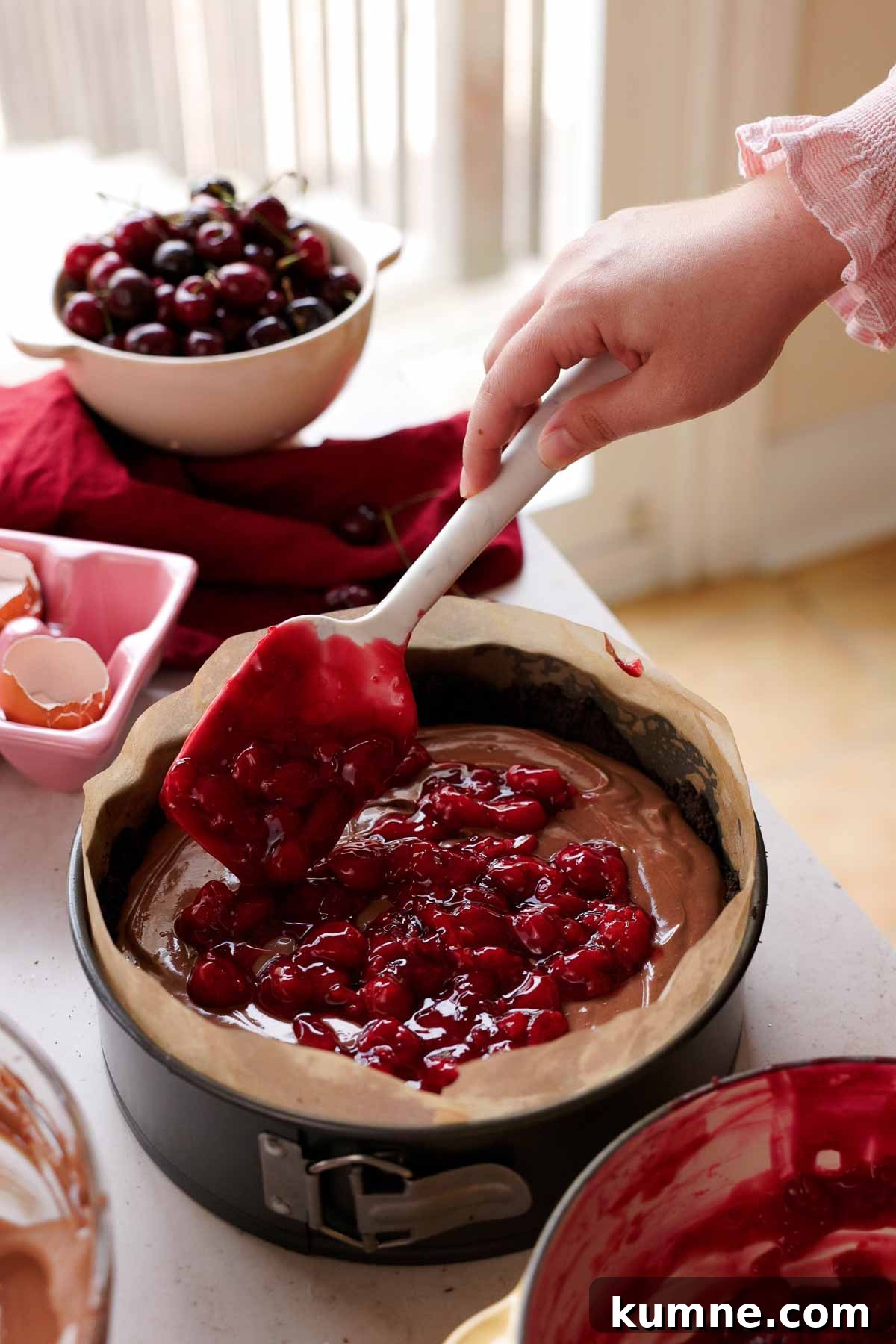 layering cherry sauce into center of cheesecake