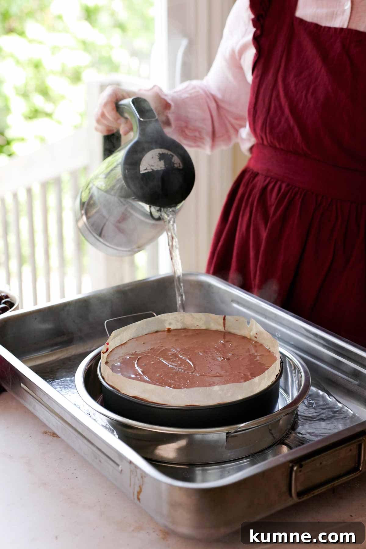 pouring boiling water into double bath for cheesecake