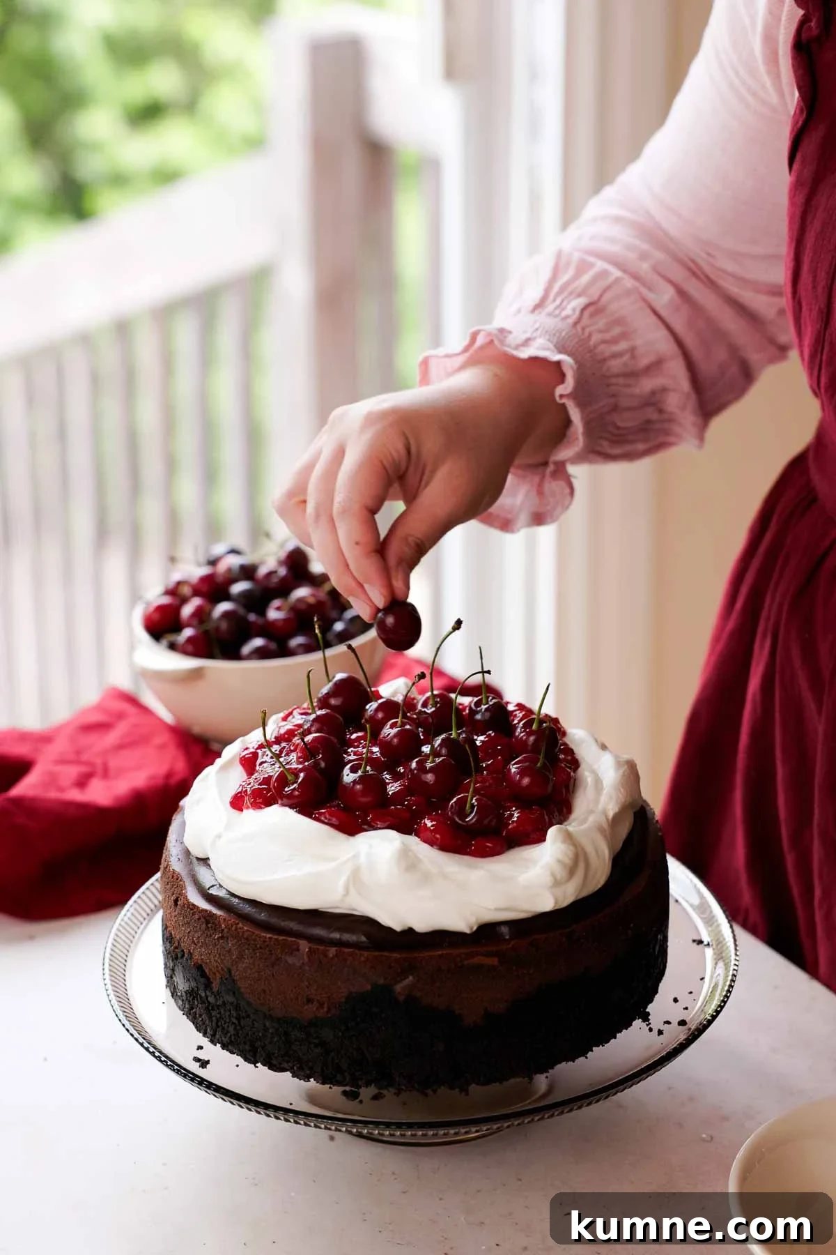 adding fresh cherries onto black forest cheesecake