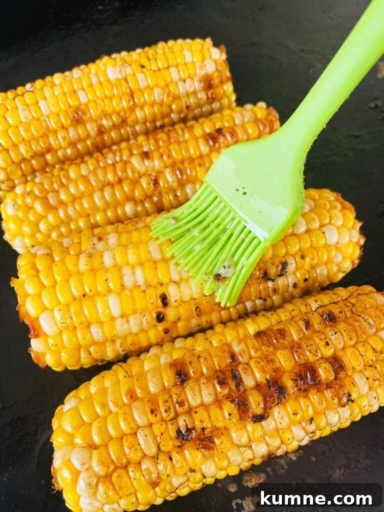 brushing the garlic butter on the corn