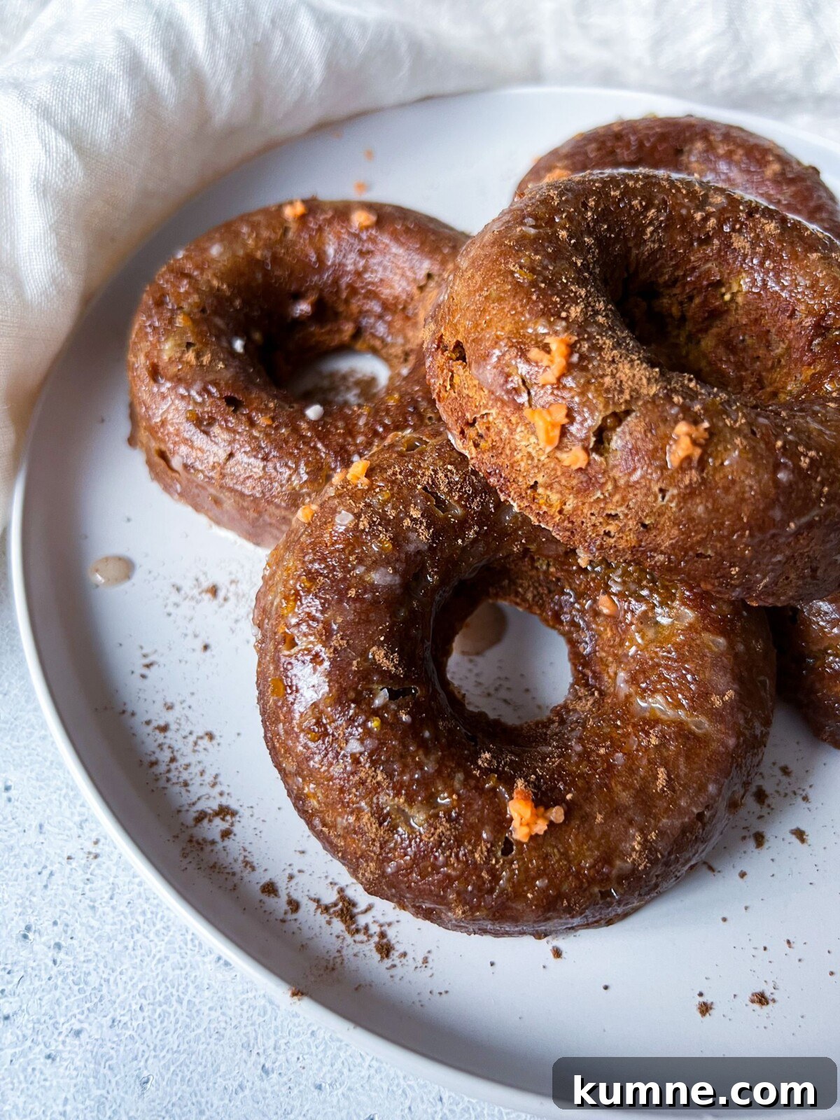 Homemade Pumpkin Spice Donuts Recipe for Fall Baking 2 A white plate with pumpkin spice donuts