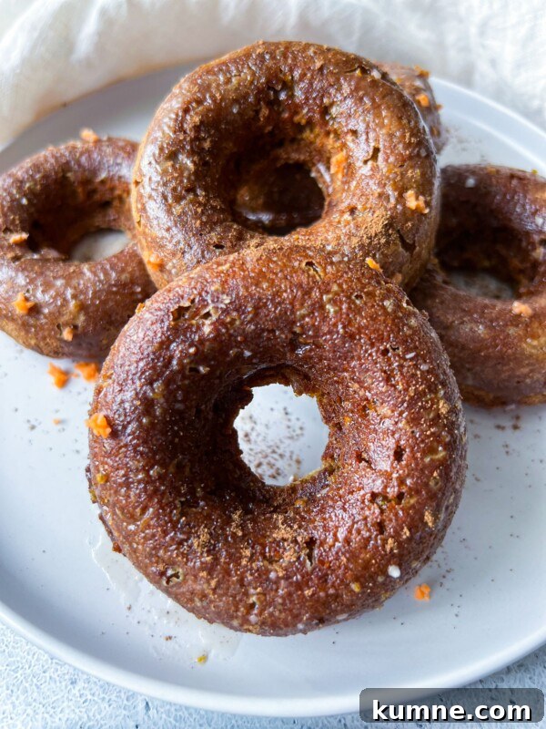 Homemade Pumpkin Spice Donuts Recipe for Fall Baking 7 Four Pumpkin Spice Donuts stacked on a white plate
