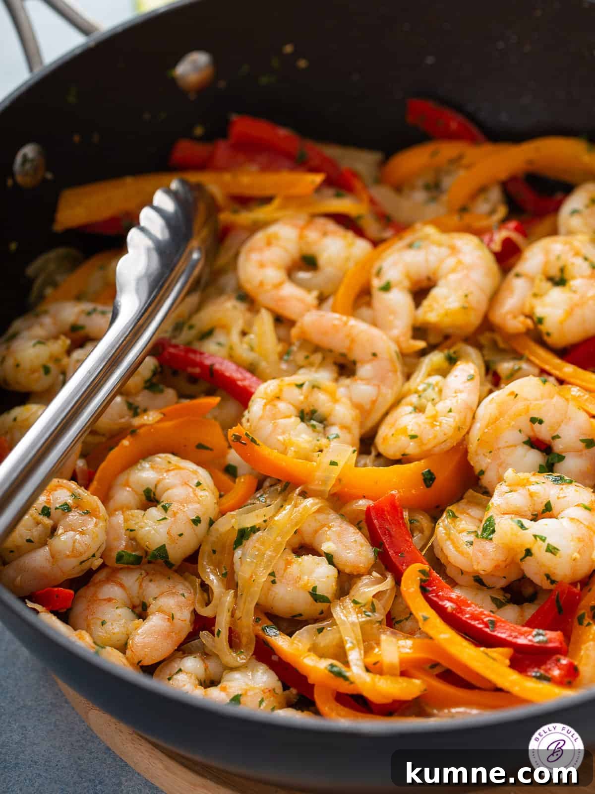 Sizzling Shrimp Fajitas Recipe for Quick Weeknight Dinner 10 Shrimp fajitas in skillet with tongs.