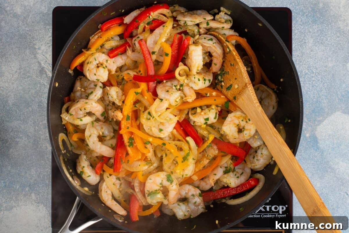 Sizzling Shrimp Fajitas Recipe for Quick Weeknight Dinner 7 Shrimp, peppers, and onion cooking in a skillet.
