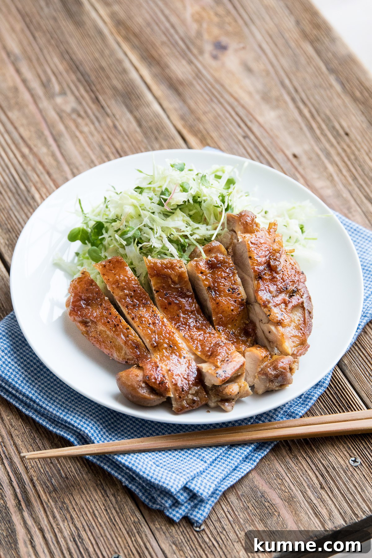 teriyaki chicken on a white plate with cabbage slaw