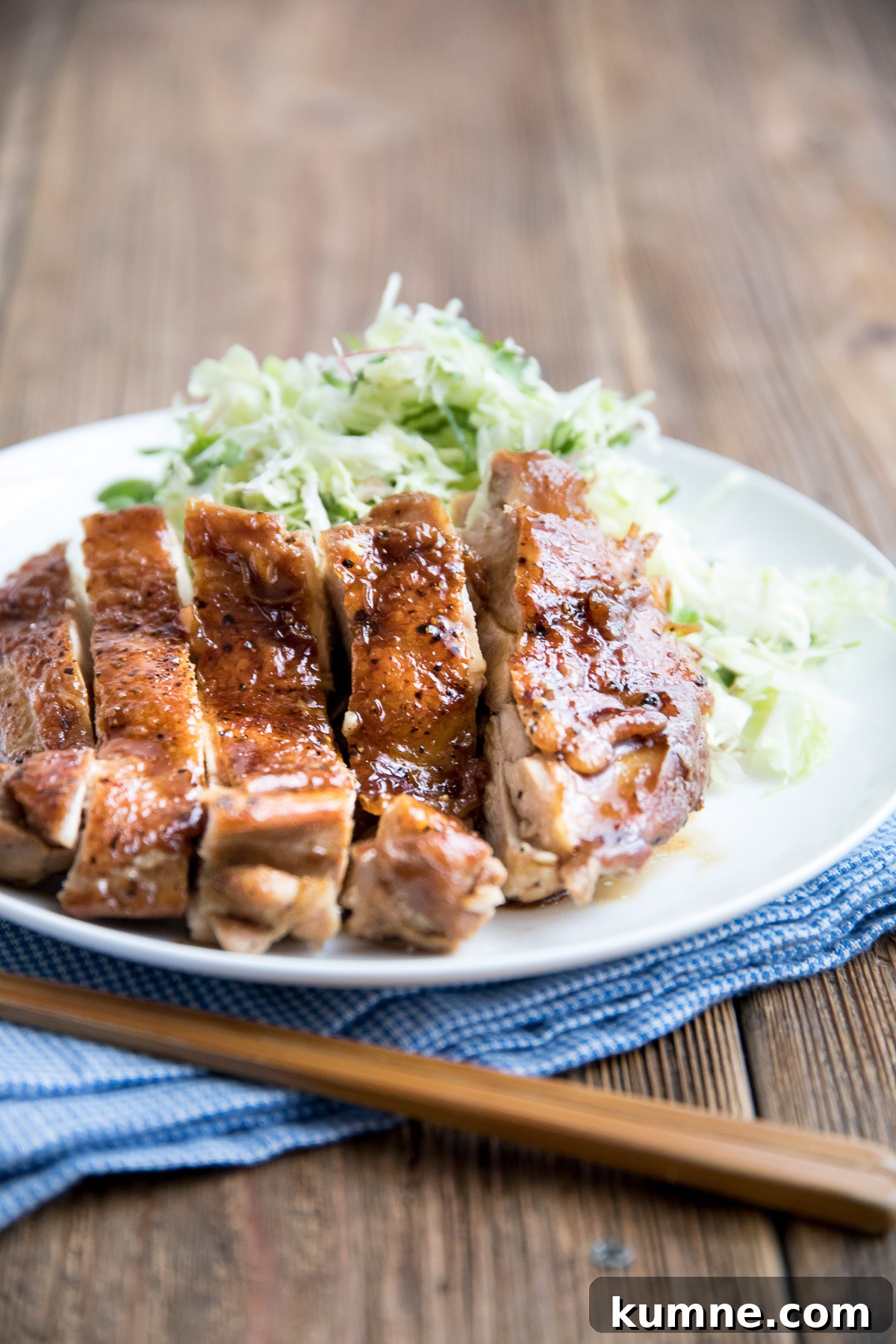 chicken teriyaki on a white plate with cabbage salad