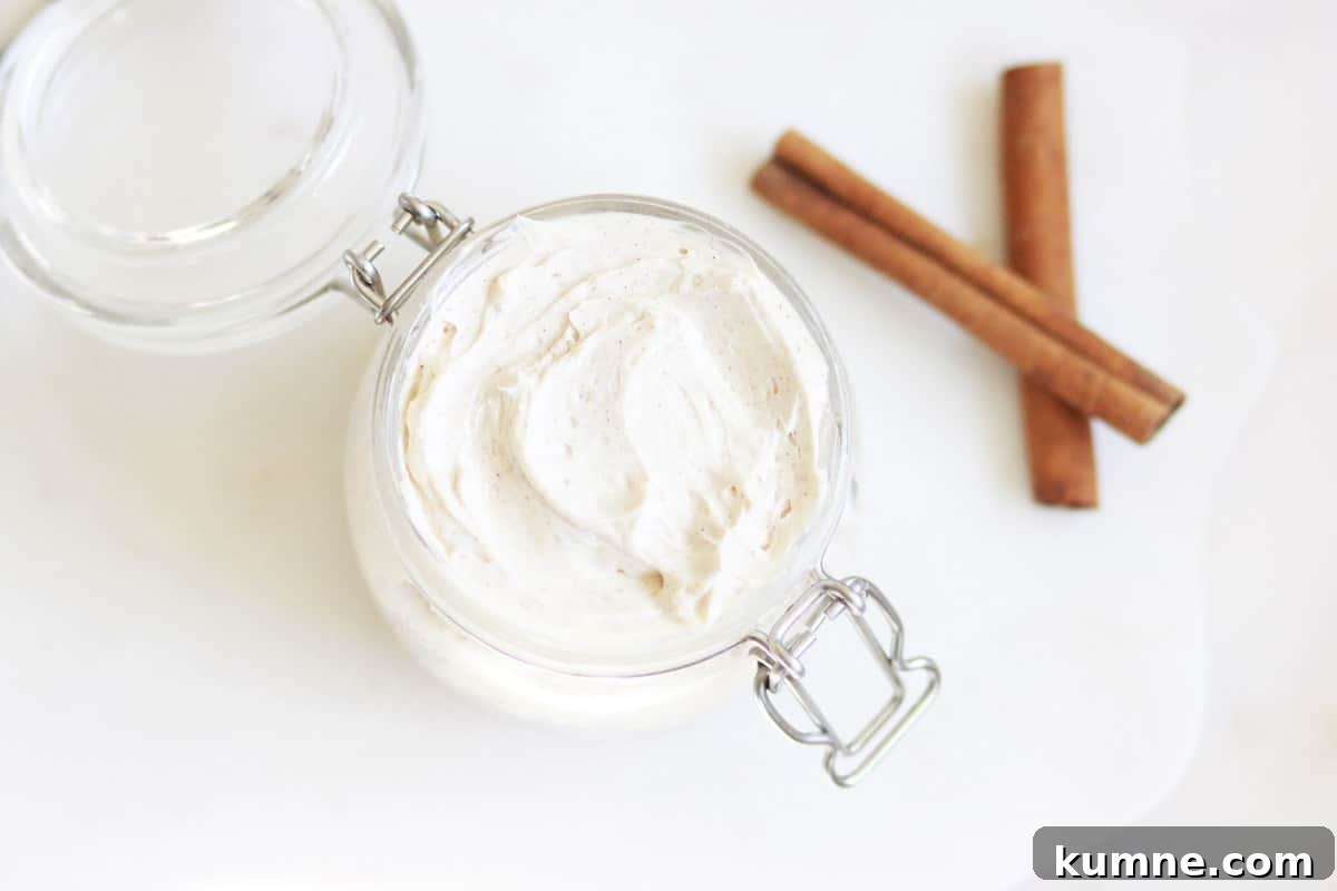 a jar of whipped gingerbread body butter with cinnamon sticks next to it