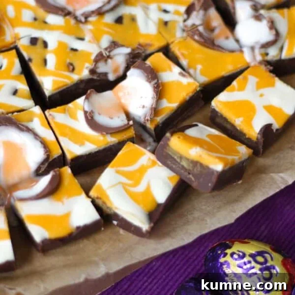 No-Bake Creme Egg Cheesecake Recipe for Spring Treat 5 Squares of Creme Egg Fudge on a baking tin, ready to eat.