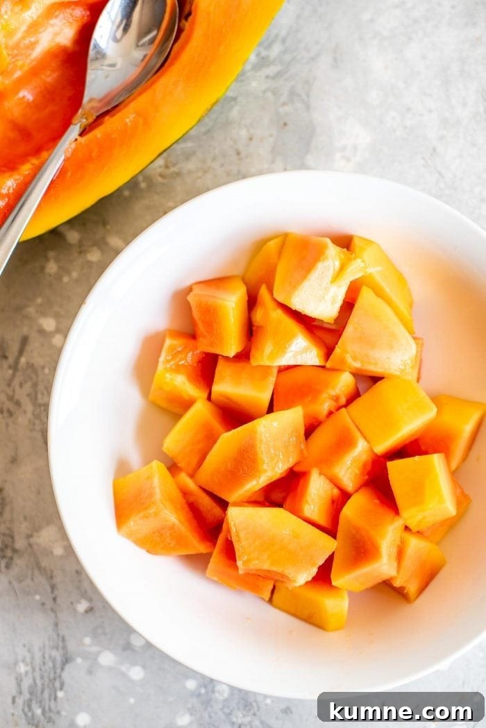 White bowl full of chopped papaya.