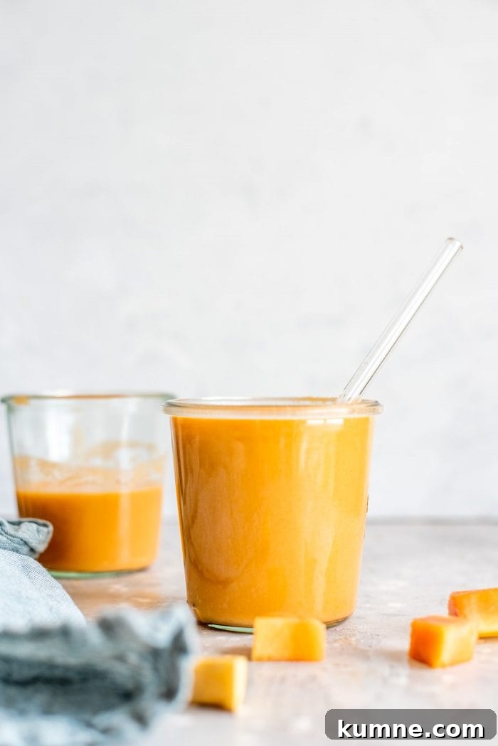 Two glasses filled with papaya banana smoothies. 