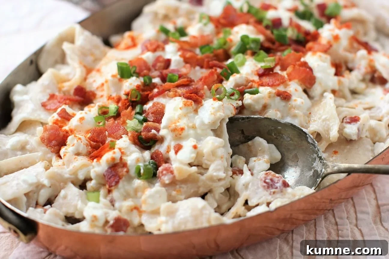 Túrós Csusza Recipe: Traditional Hungarian Cottage Cheese Pasta 3 scooping up a portion of creamy this creamy Hungarian pasta dish