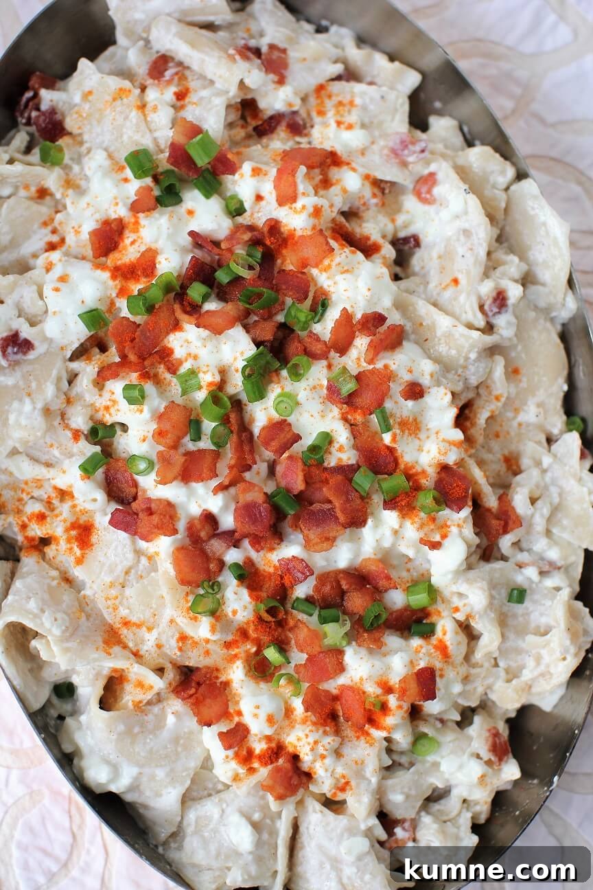 Túrós Csusza Recipe: Traditional Hungarian Cottage Cheese Pasta 5 top down view of a dish of Turos Csusza with bacon and green onions on it
