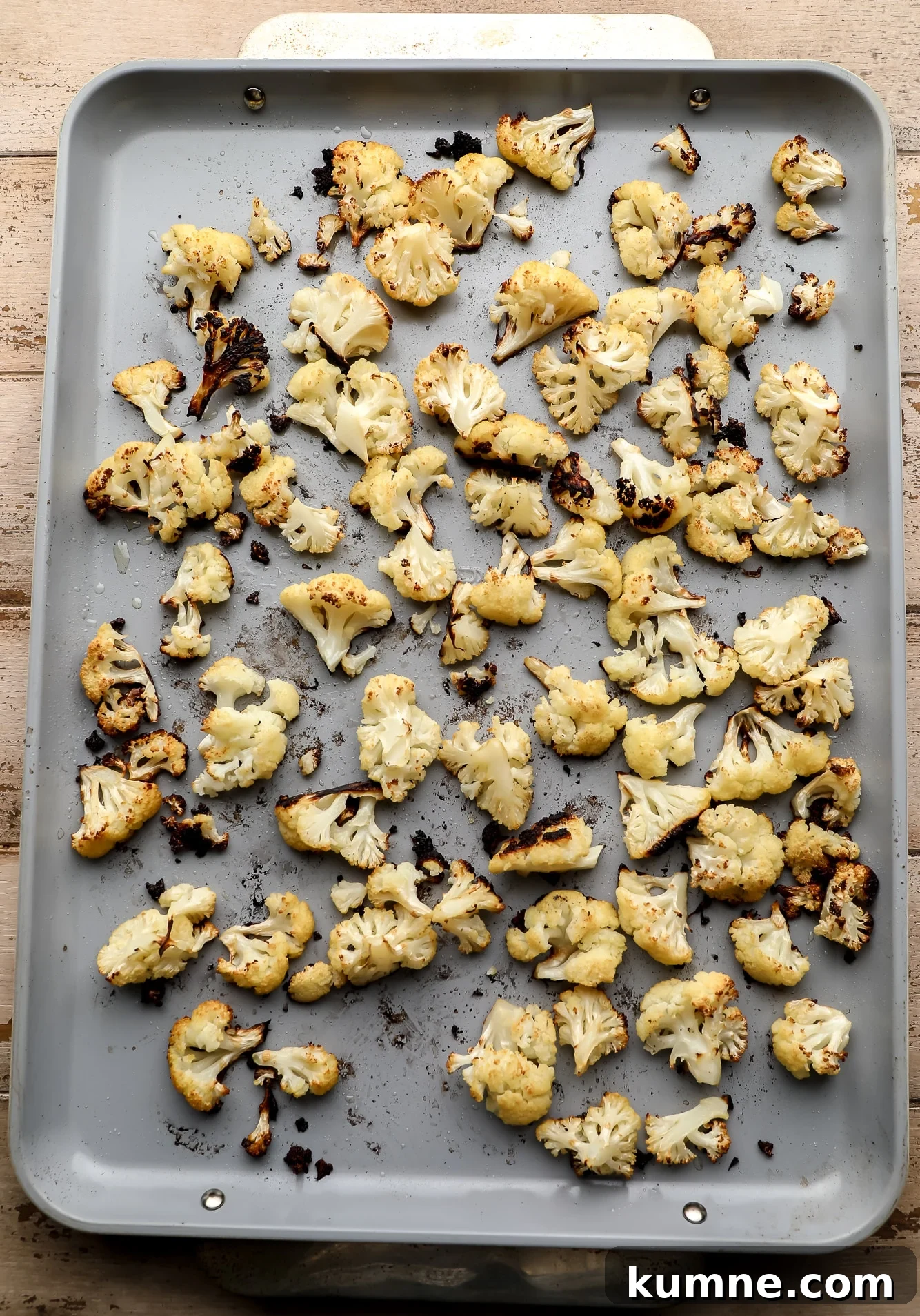 roasted cauliflower florets on a large metal baking sheet.