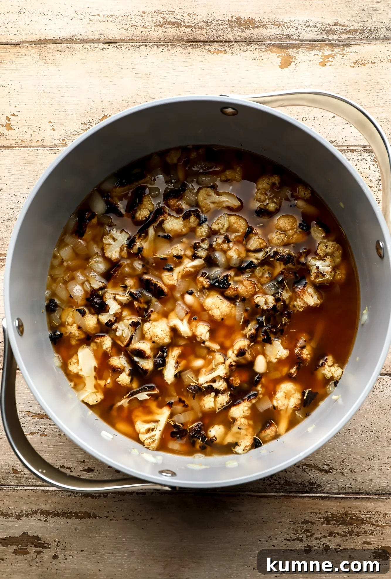 the ingredients for roasted cauliflower soup in a large grey pot.
