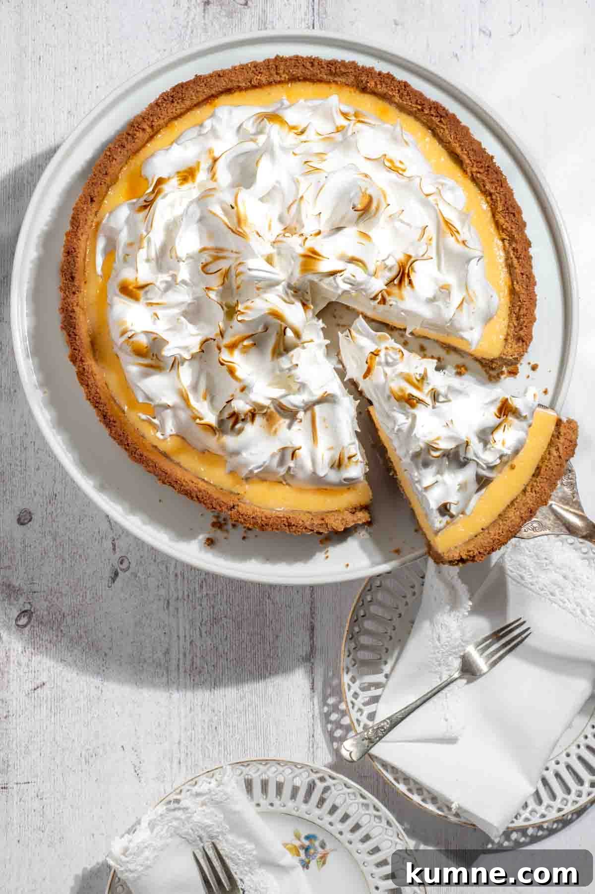 Lemon Meringue Pie with a Crispy Biscuit Crust 3 Biscuit base lemon meringue pie with one sliced piece.