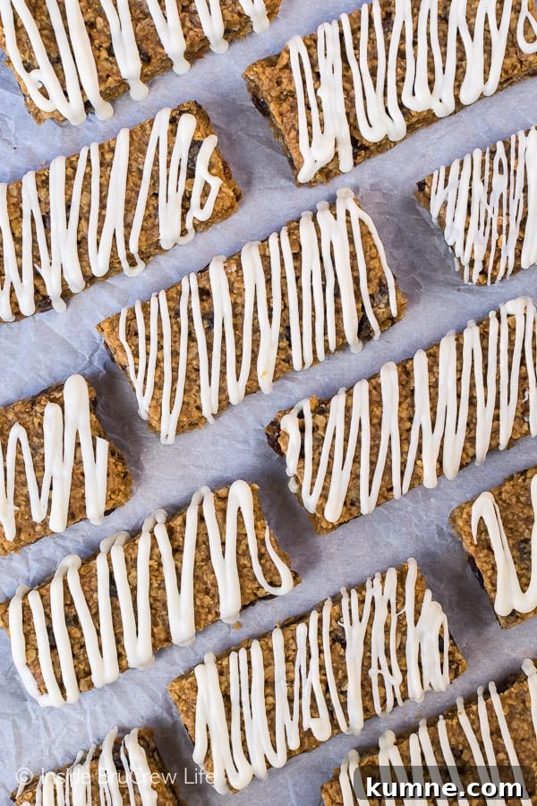 A white background with gingerbread oatmeal bars with white chocolate drizzles on it