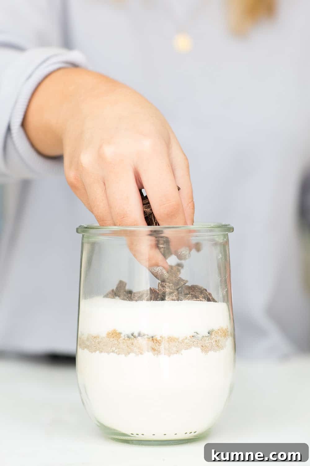 layering chocolate on top layer in jar, creating cookie mix in a jar