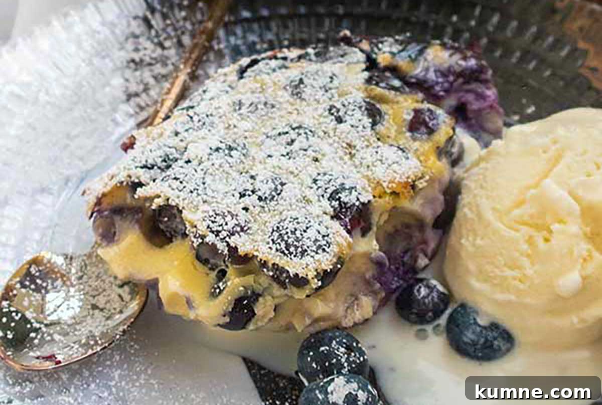 20+ Gluten-Free Blueberry Recipes for Delightful Desserts and Snacks 18 A slice of easy blueberry clafoutis with a custard-like texture, served warm on a plate alongside a scoop of creamy vanilla ice cream—simple, elegant