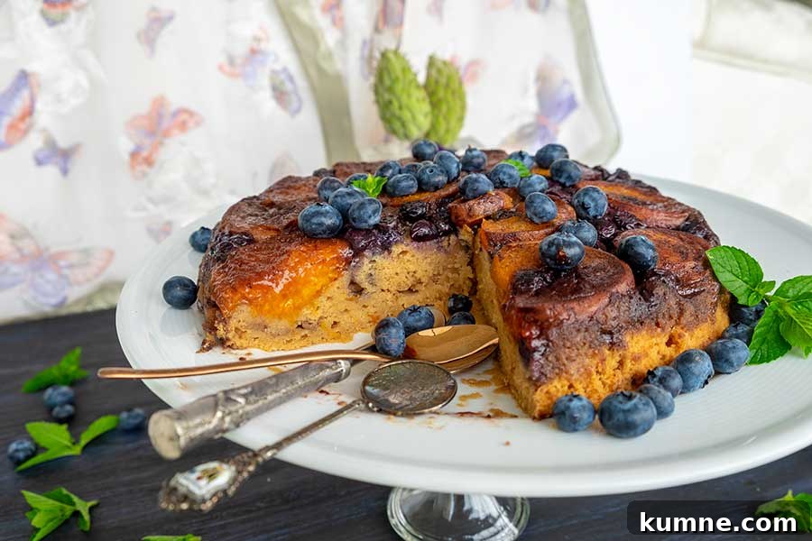 20+ Gluten-Free Blueberry Recipes for Delightful Desserts and Snacks 5 Fresh apricot and blueberry gluten-free tarte Tatin served on a dessert platter, with two spoons beside it and the juicy, caramelized fruit filling and fresh blueberries visible inside—perfect for a summer dessert.