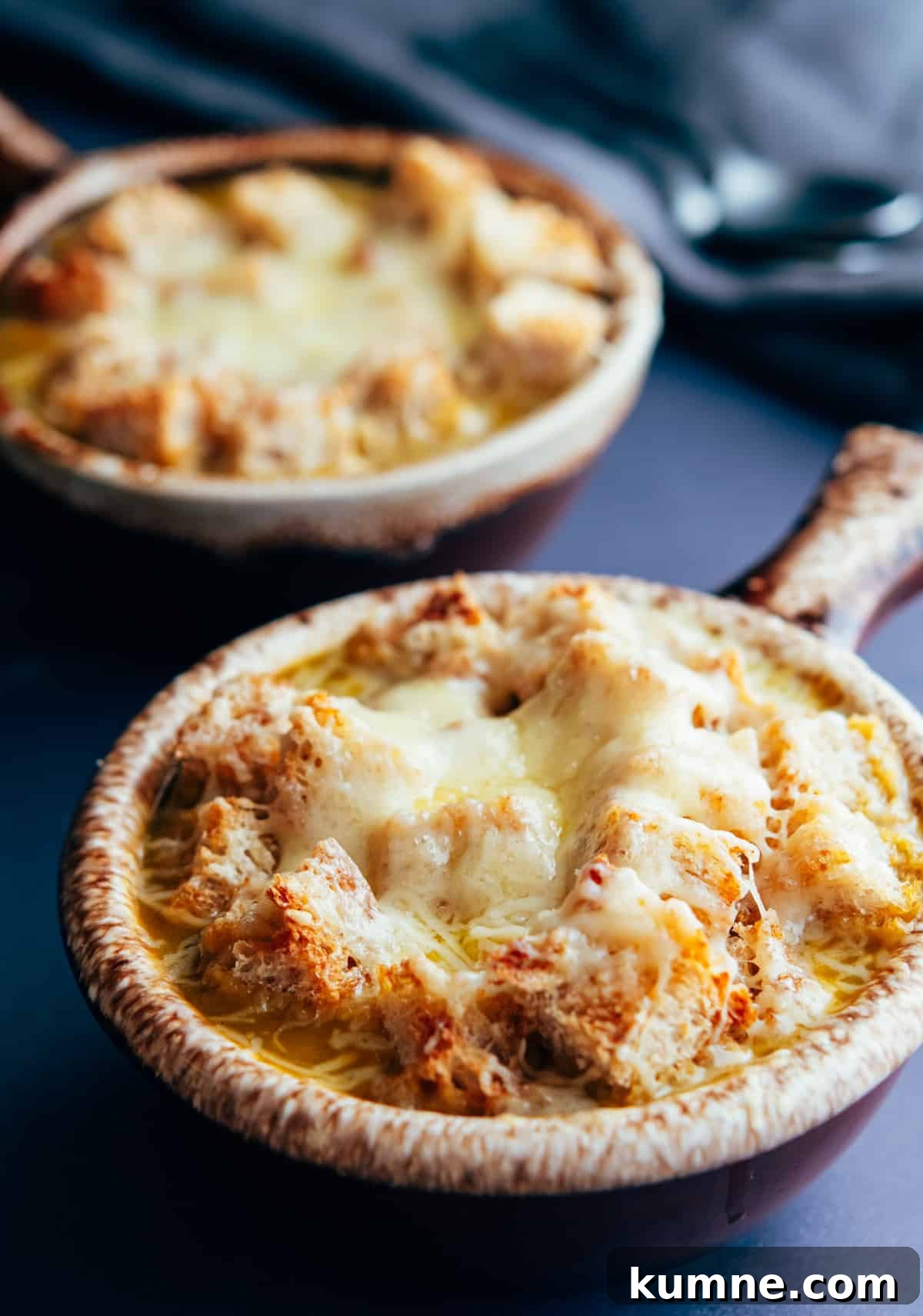 Vegetarian French Onion Soup served in traditional brown bowls with a long handle