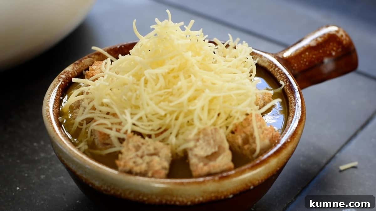 topping soup and bread with shredded cheese