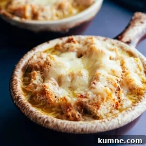 Vegetarian French Onion Soup served in traditional brown bowls with a long handle