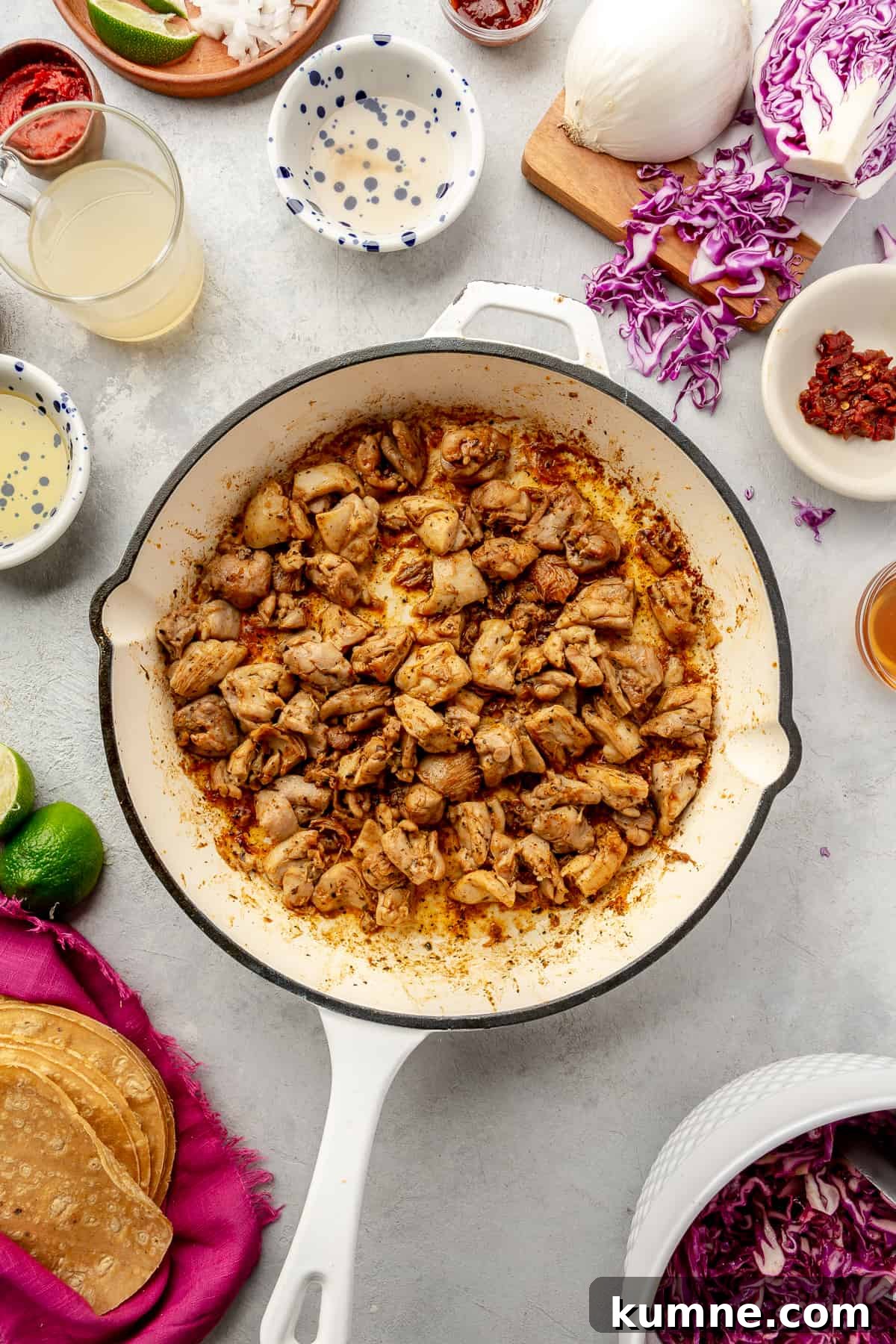 Sticky Chipotle Chicken Tacos with Smoky Lime Slaw 6 Seasoned chicken in skillet. Taco ingredients scattered around.