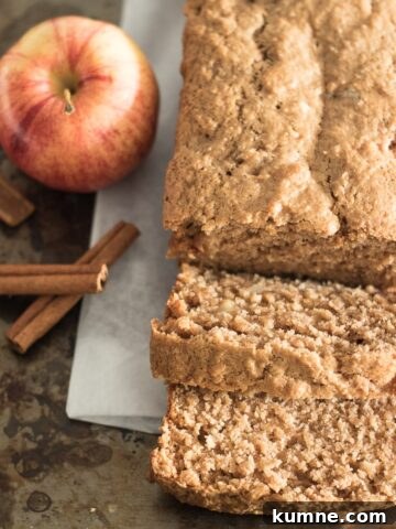 Flat image of sliced apple bread, apple and cinnamon sticks.