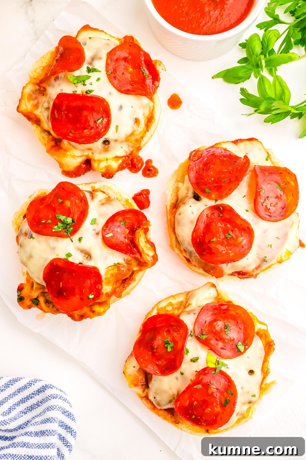 Pizza Burger Recipe: Juicy Cheeseburger with Pizza Flavor 9 Four pizza burgers without the top bun on them so you can see the beef patty, sauce, melted mozzarella cheese, and pepperoni.