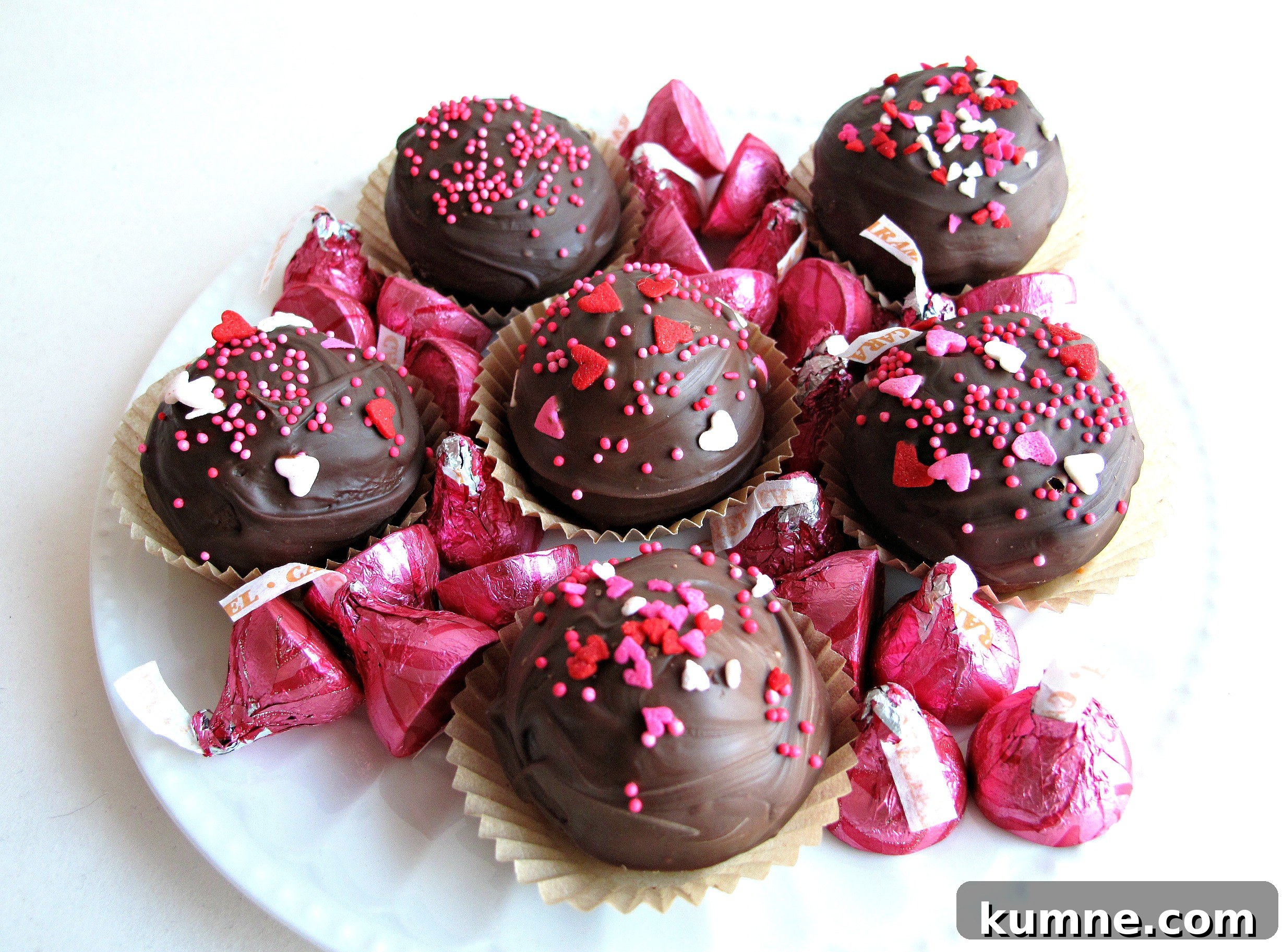 Valentine Sugar Cookies for Care Packages: Military Edition #9 8 Kiss Cookies, ball-like chocolate cookies dipped in chocolate and sprinkled with Valentine sprinkles, on a plate with pink foil Hershey's kisses