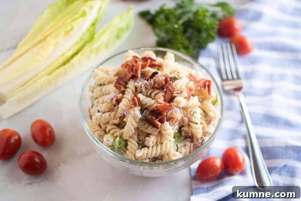 Overhead shot of a glass bowl filled with BLT pasta salad.