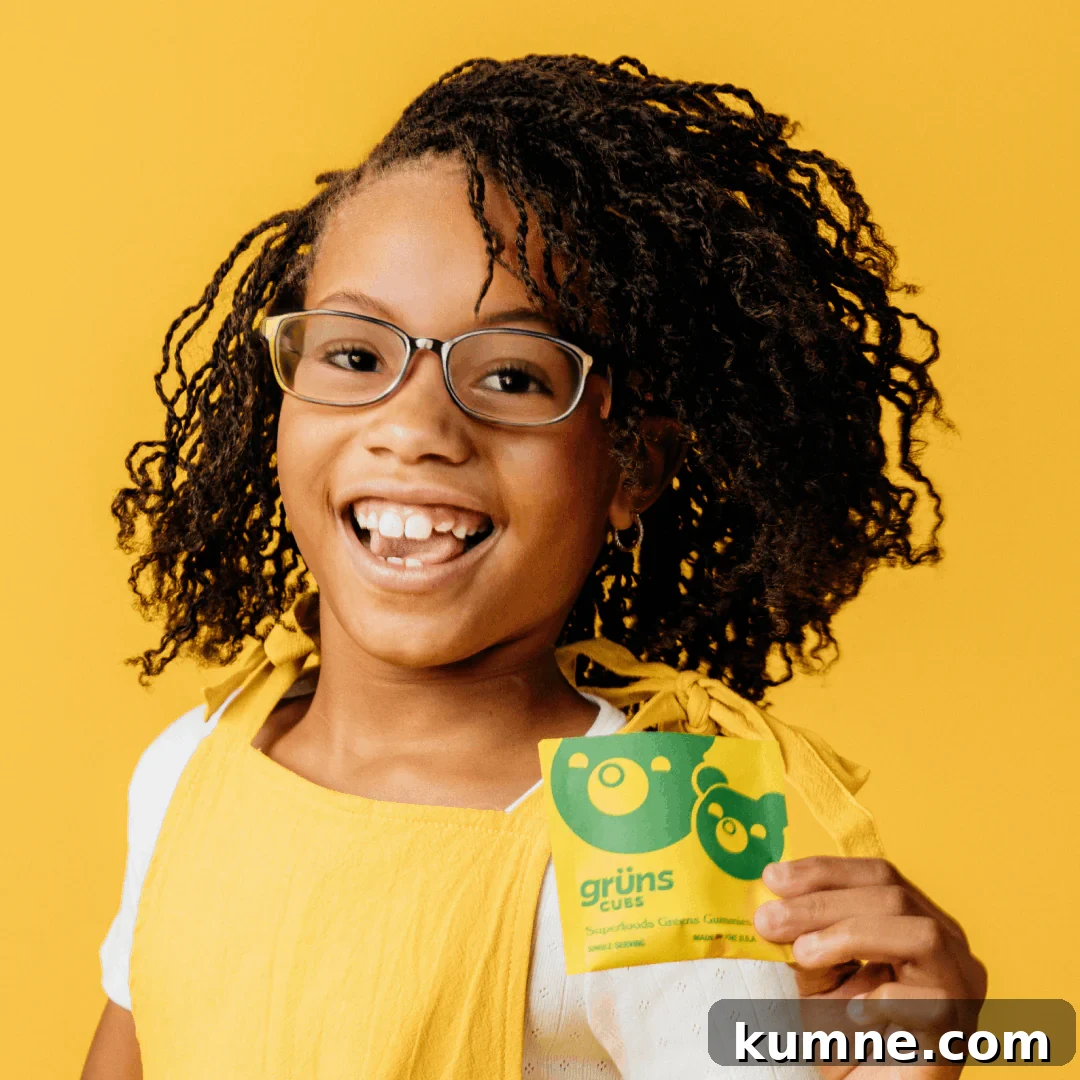 Organic Kids Vitamins: Top Picks Without Artificial Additives 8 a girl holding a snack pack of Grüns cubs Superfoods Greens Gummies