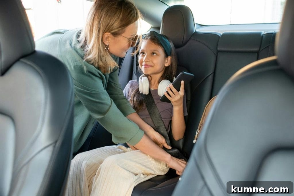 mom buckling her daughter into her seat in the car
