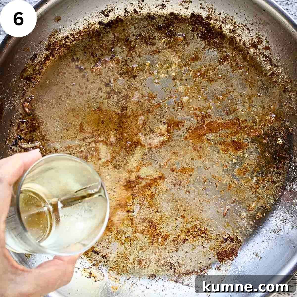Pouring white wine into a pan which has been used to fry and has browned bits.