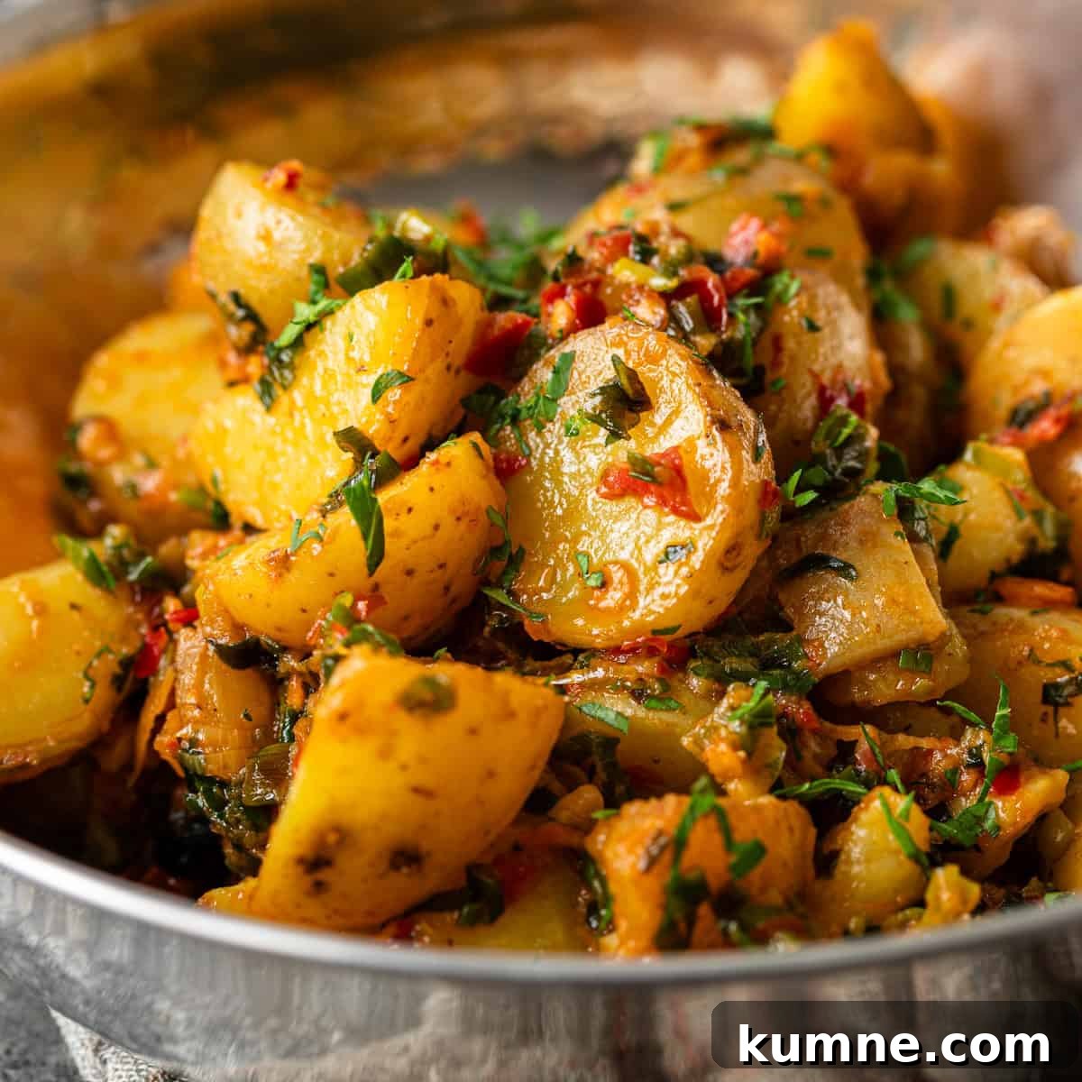 Spicy Calabrian Roasted Potatoes Recipe 2 closeup: pan fried calabrian potatoes with chilies and herbs in a metal bowl