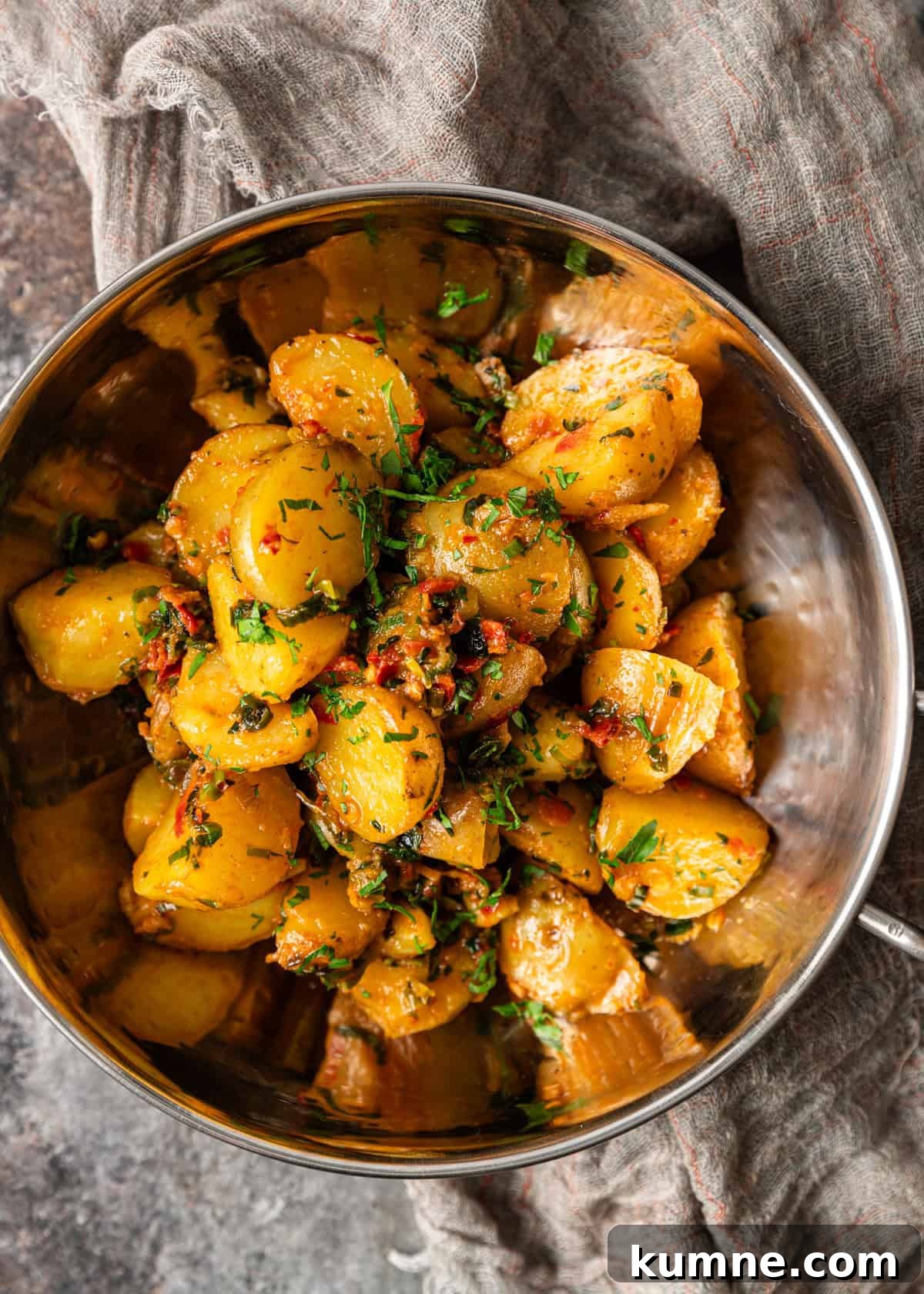 Spicy Calabrian Roasted Potatoes Recipe 6 overhead: a metal bowl full of calabrian chili potatoes with herb butter