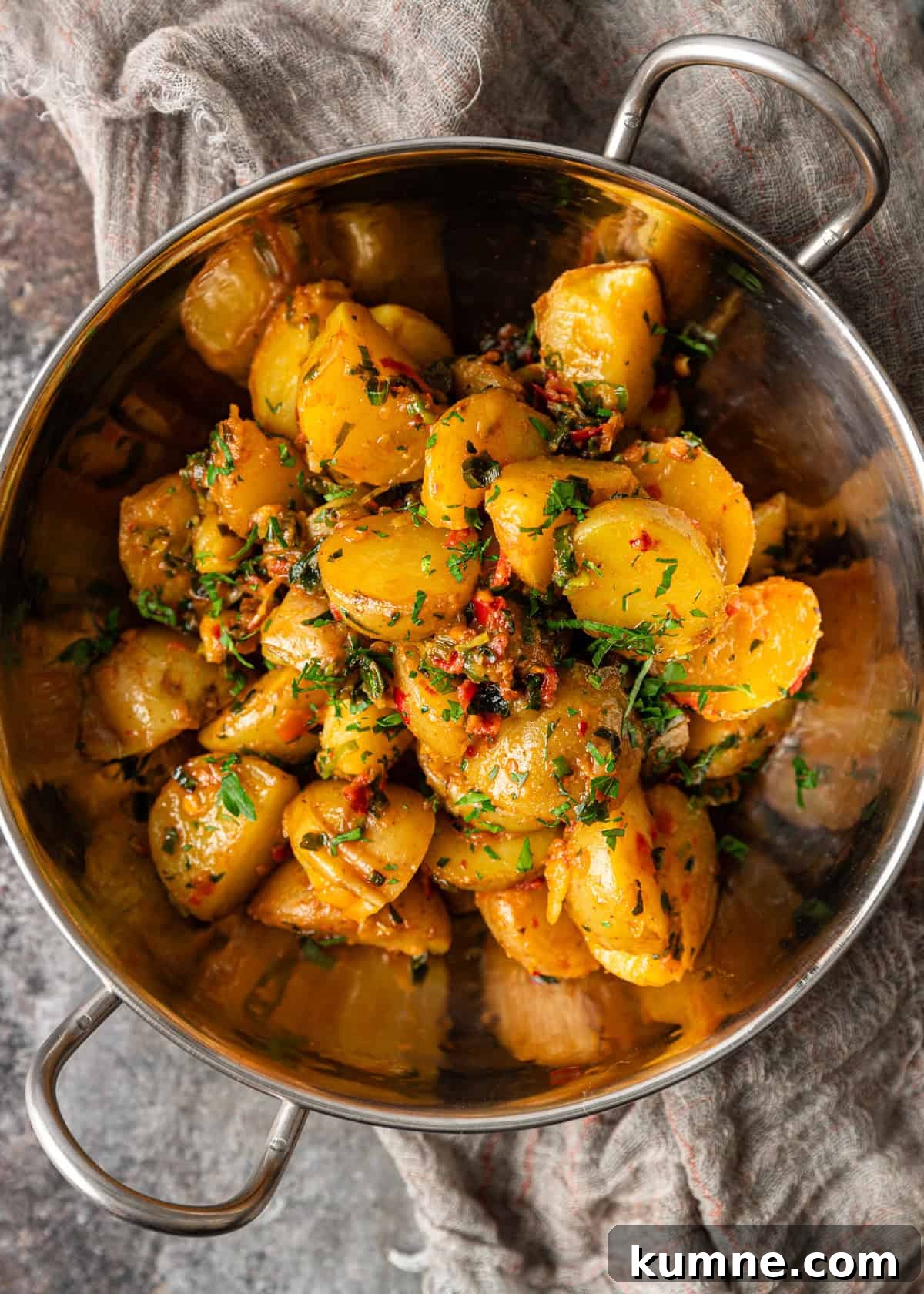 Spicy Calabrian Roasted Potatoes Recipe 8 overhead: potatoes and peppers cooked in herb chili butter in a metal bowl