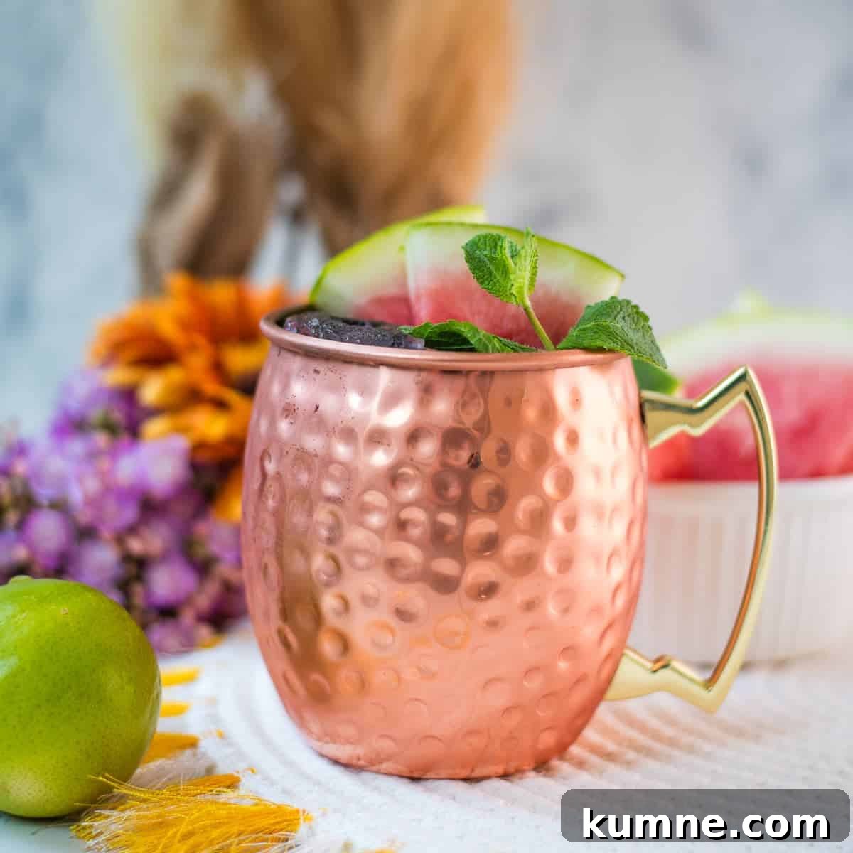 Gorgeous copper mug, filled with a delicious watermelon Moscow mule. Garnished with watermelon slices and mint leaves.