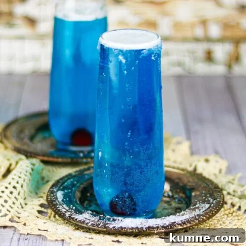 Two dark blue cocktails in champagne flutes.