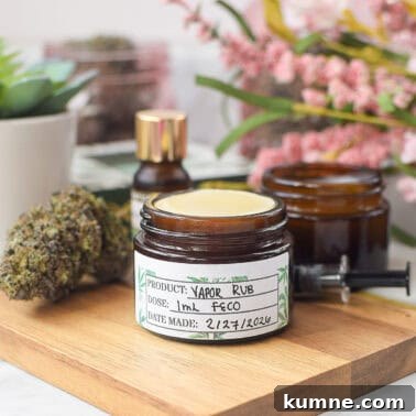 Cannabis-infused vapor rub jar with herbs and essential oils on wooden surface.