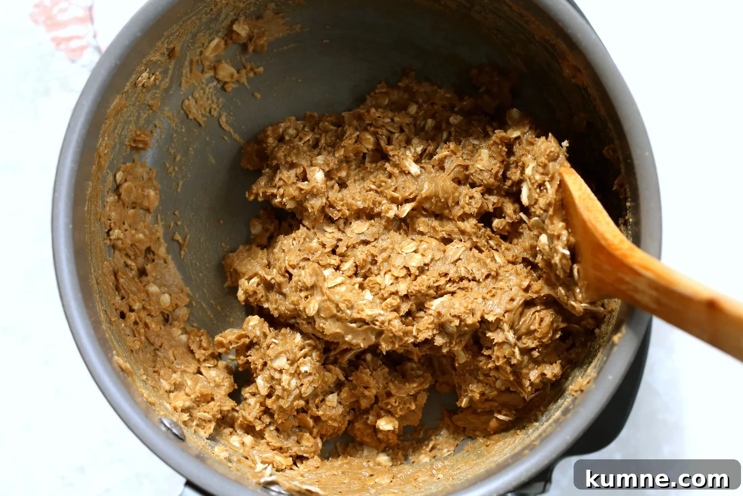 Oats mixed in the sunbutter mixture in a saucepan for our Sunbutter Granola Bars