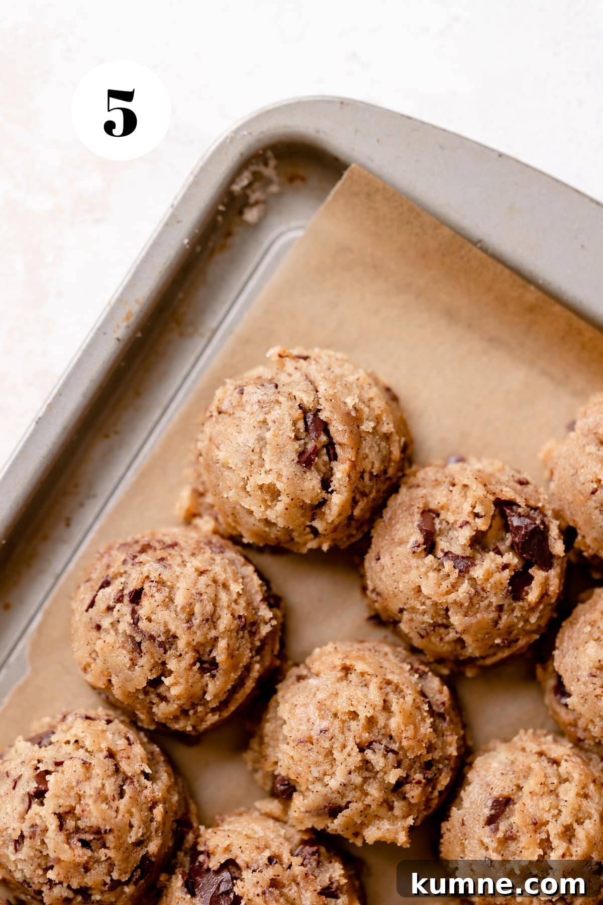 Espresso Chocolate Chip Cookies Recipe — Rich Coffee Cookie Delight 5 espresso chocolate chip cookie dough balls on a baking tray.