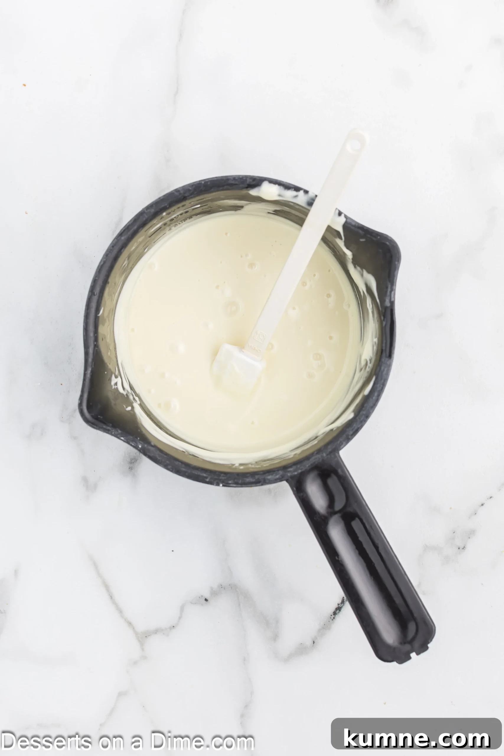 Melted white chocolate in a saucepan.