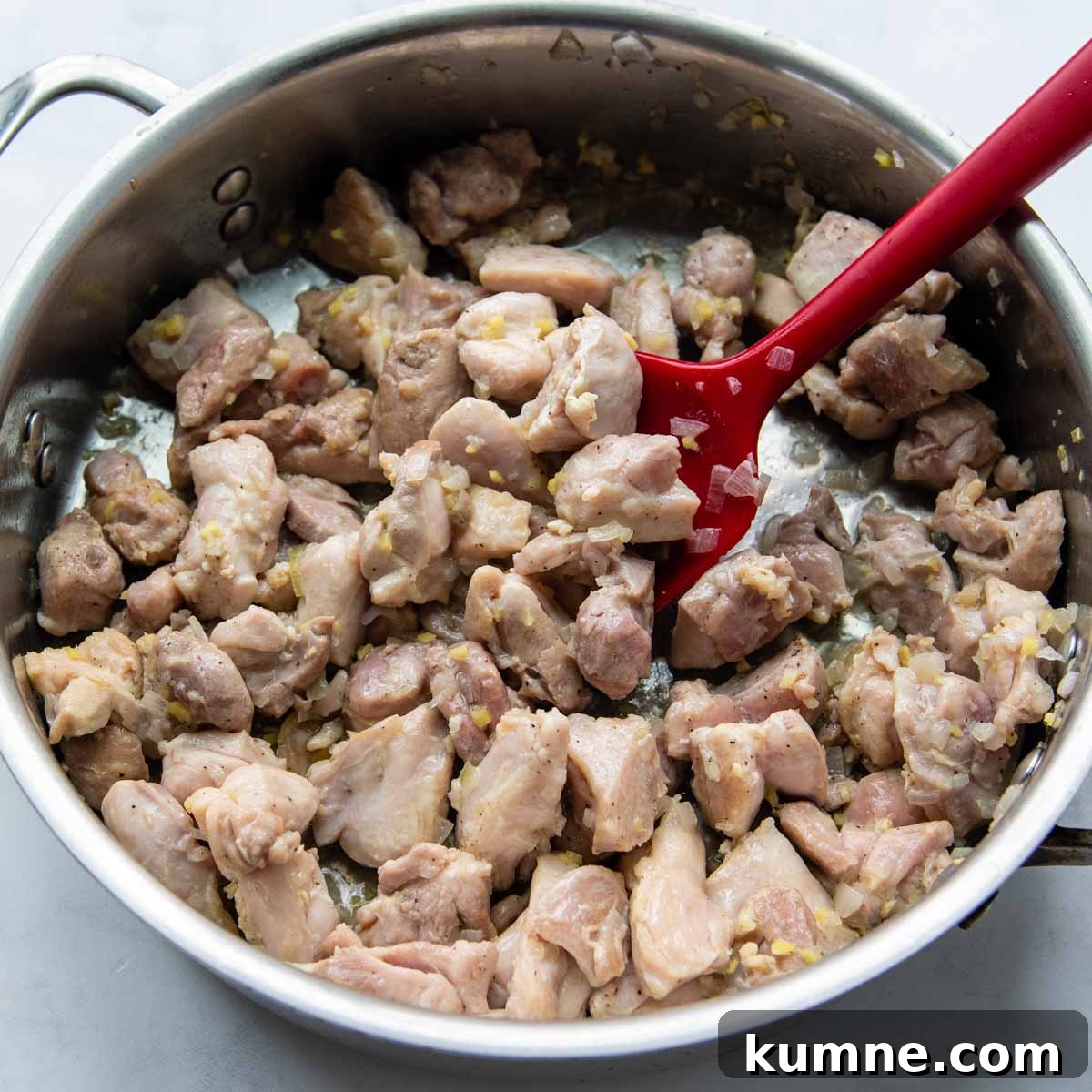 chicken thighs cooking in a skillet.