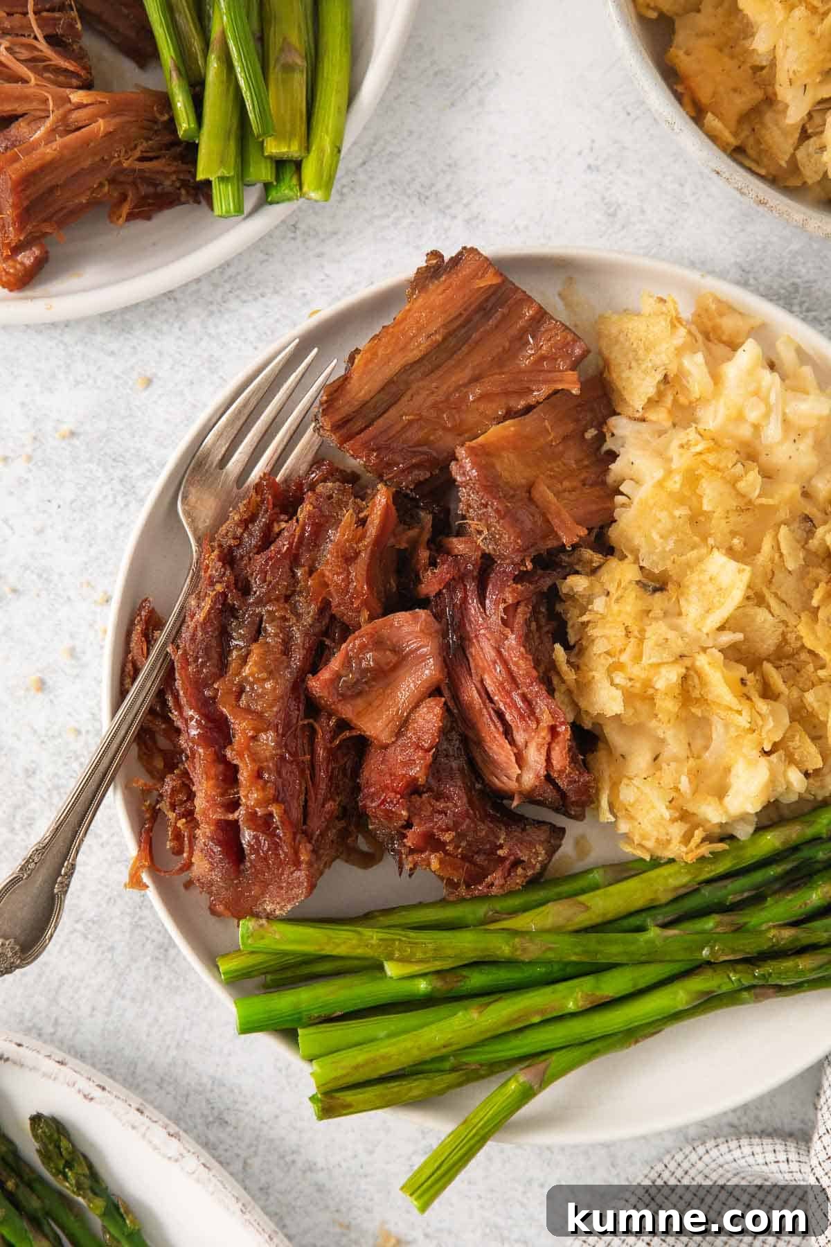 Gluten-Free Baked Ham Recipe for Flavorful Holiday Meals 3 gluten-free ham on a plate with cheesy potatoes and asparagus
